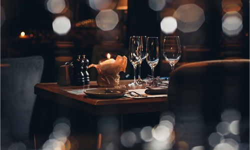 wine glasses and a candle in a warm lit restaurant